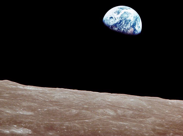 the Earth rising over the Moon's horizon